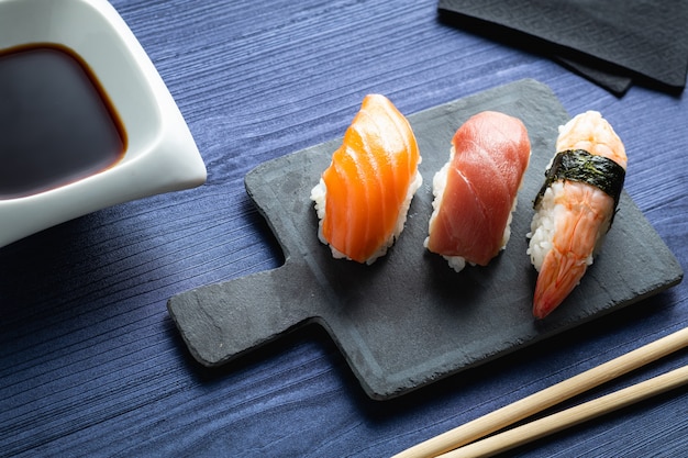 Elegant sushi on wood table. Some Nigiri, with soy sauce and chopstick