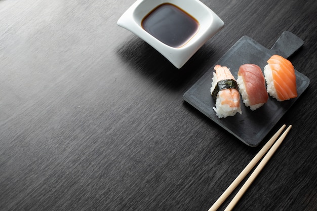 木製のテーブルにエレガントな寿司。にぎり、醤油と箸