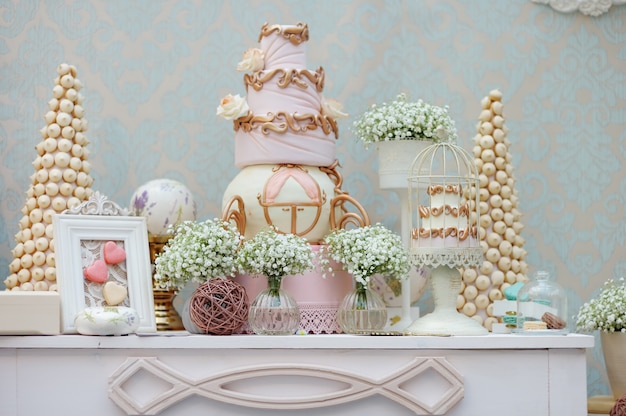 Elegant sweet table with big cake and macaroon on dinner or event party 