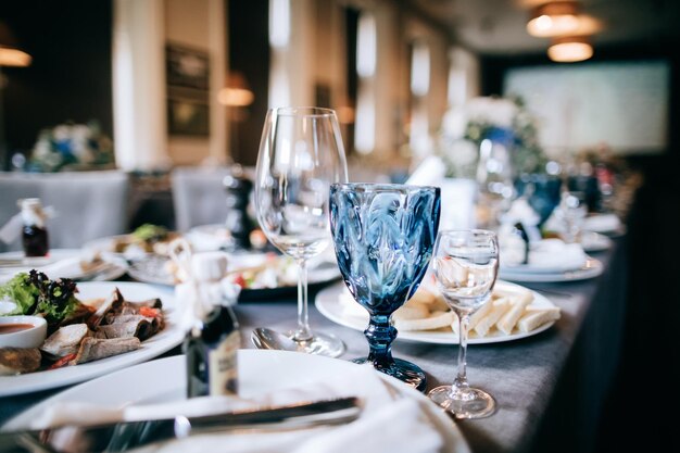 Elegante tavola per una cena di matrimonio in un ristorante bicchieri blu