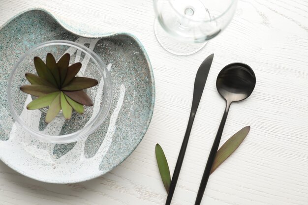 Elegant table setting with floral decor on white wooden background flat lay