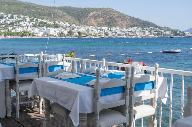 Elegant table setting with fork knife wine glass white plate and blue napkin in restaurant Nice dining table set with arranged silverware and napkins for dinner