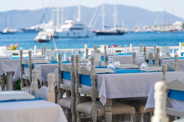 Elegant table setting with fork, knife, wine glass, white plate and blue napkin in restaurant