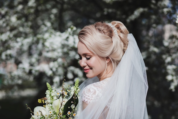 Elegant tender bride with bouquet of flowers outdoors. Wedding day