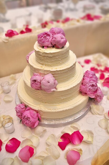 An elegant tiered buttercream wedding cake decorated with peonies  high quality photo