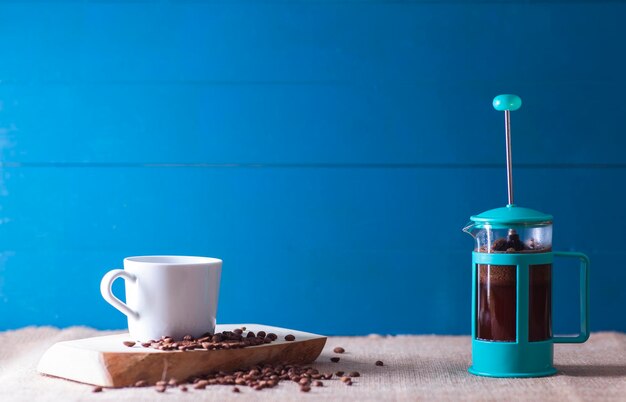 Photo elegant view of a mug coffee beans and a french press copy space includes vintage looking in blue tones