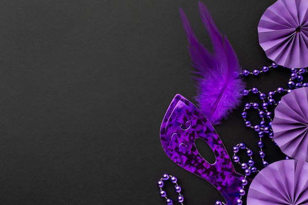 Foto elegante maschera viola e decorazioni su fondo scuro