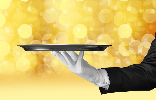 Elegant waiter hand in white glove holding an empty plate