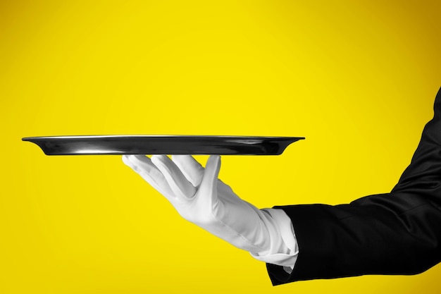 Photo elegant waiter hand in white glove holding an empty plate