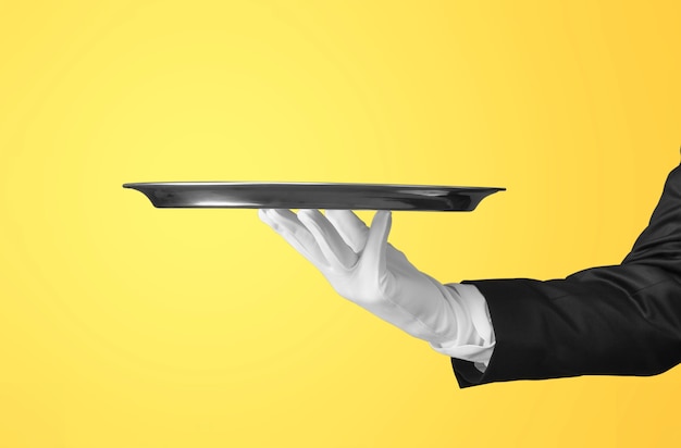 Photo elegant waiter hand in white glove holding an empty plate