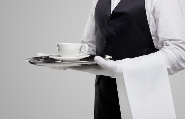 Elegant waiter serving cup of coffee