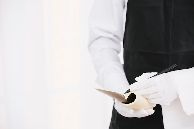 Elegant waiter writing a note