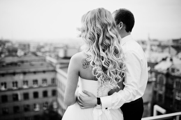 Elegant wedding couple on the roof with high-tech architecture line