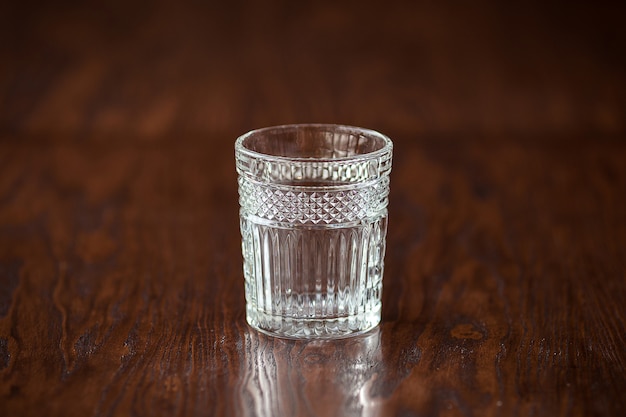 Elegant whiskey glass on the dark wooden table