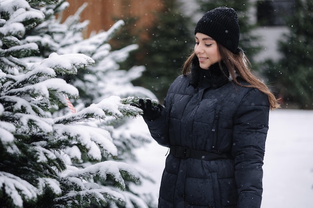 Elegant woman buys a christmas tree woman in a black knited sweater beautiful lady choose fir tree