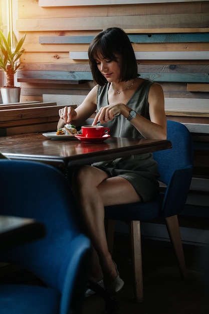 Elegant woman eating a pie topped with icecream with fork and knife no face