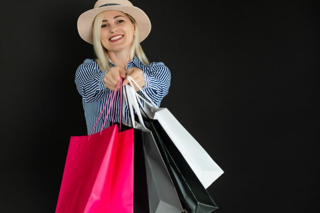 Elegant woman holding black shopping bags, black friday concept