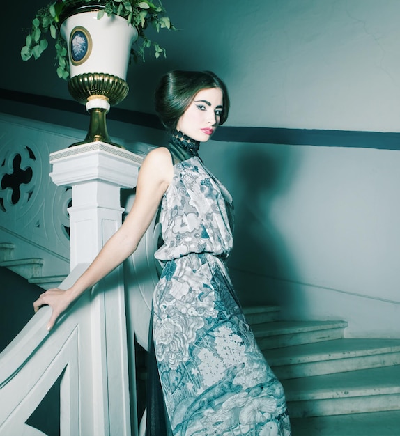 Elegant woman in long dress on vintage stairs