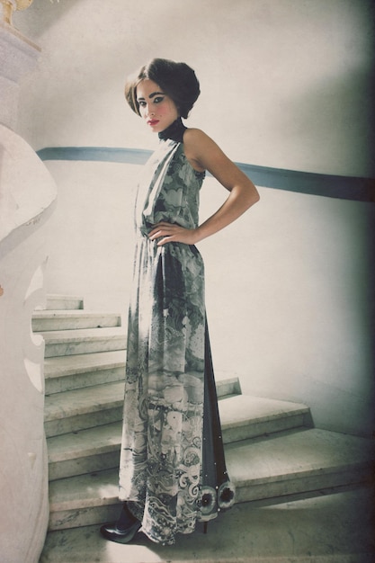 Elegant woman in long dress on vintage stairs