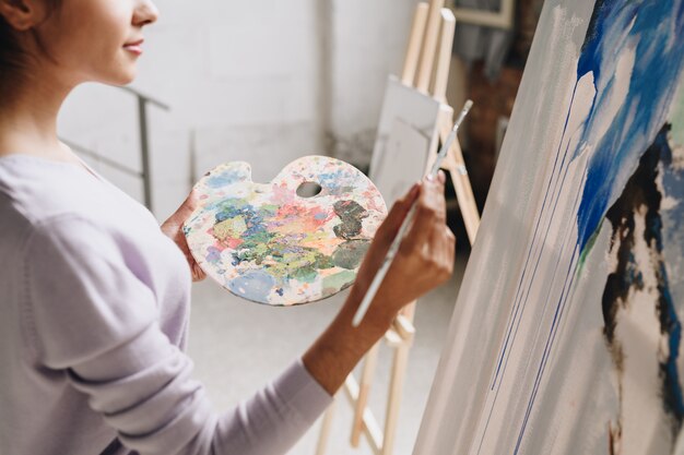 Elegant Woman Painting in Art Studio