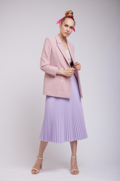 elegant woman in pretty pastel  pink jacket, lilac skirt on white background