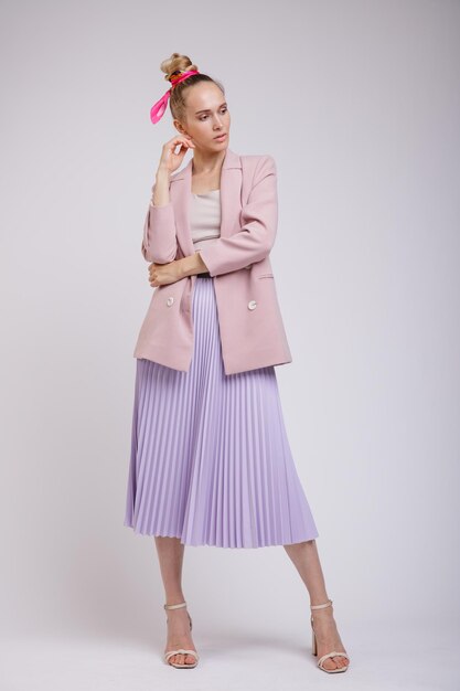 elegant woman in pretty pastel  pink jacket, lilac skirt on white background