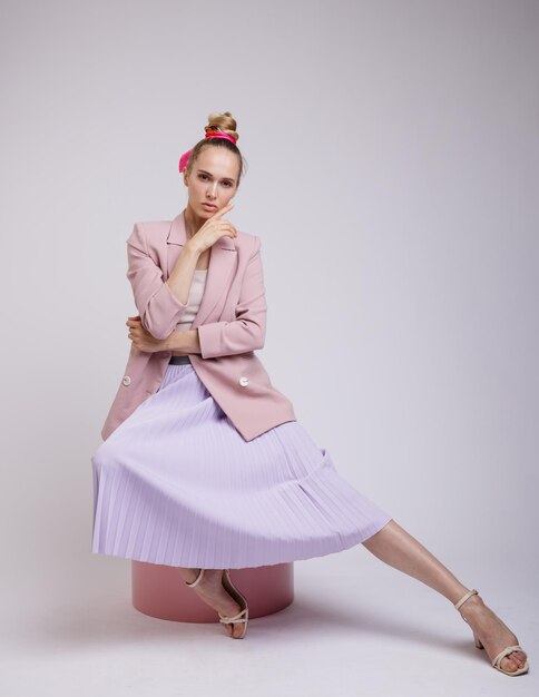 elegant woman in pretty pastel  pink jacket, lilac skirt on white background