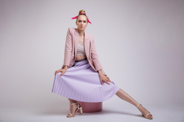 elegant woman in pretty pastel  pink jacket, lilac skirt on white background