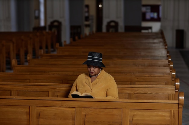 Элегантная женщина читает Библию в церкви