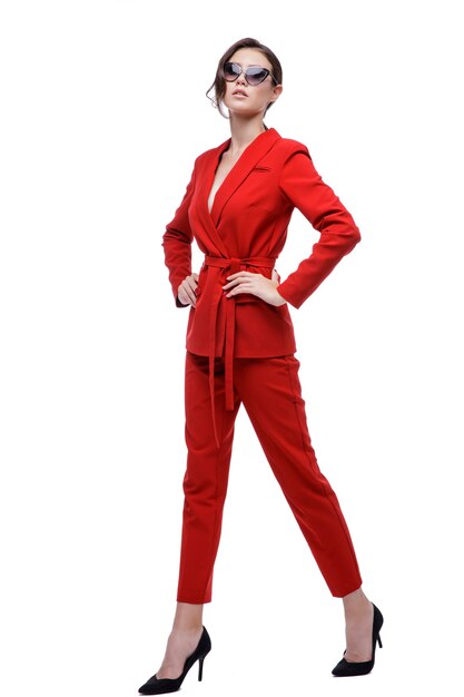 Elegant woman in red suit jacket pants sunglasses on white background Studio Shot Businesswoman