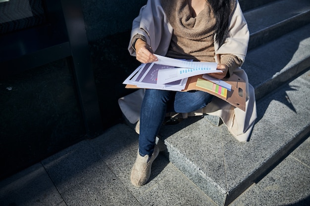 Elegant woman studying documents on the street