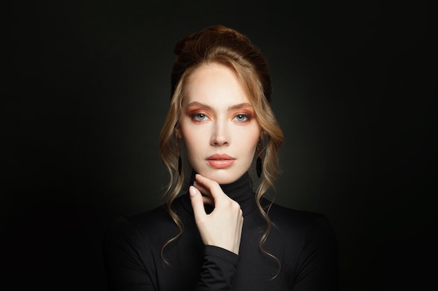 Elegant woman wearing black turtleneck sweater on black background portrait