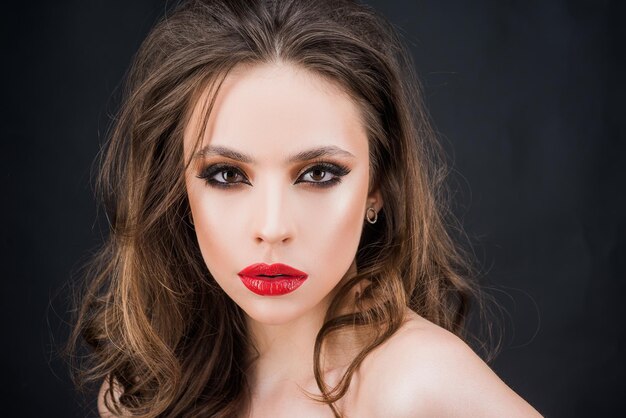 Elegant woman with red lips and smokey eyes makeup closeup face with makeup