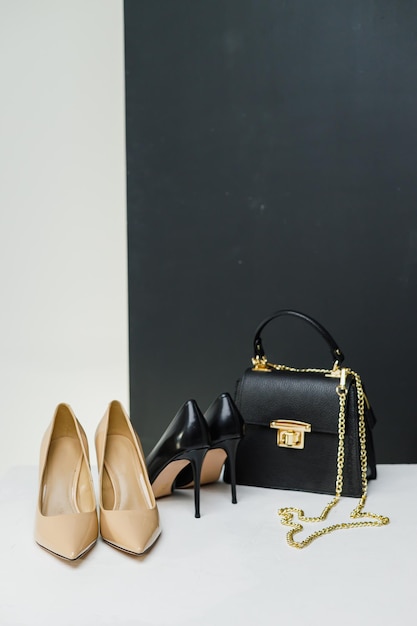 Elegant women's pumps with heels stand next to a black handbag on a white background Place for writing
