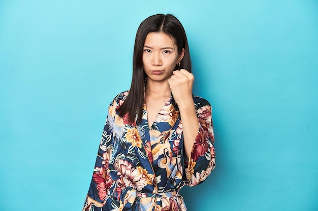 Elegant young Asian woman in kimono studio shot showing fist to camera aggressive facial expression