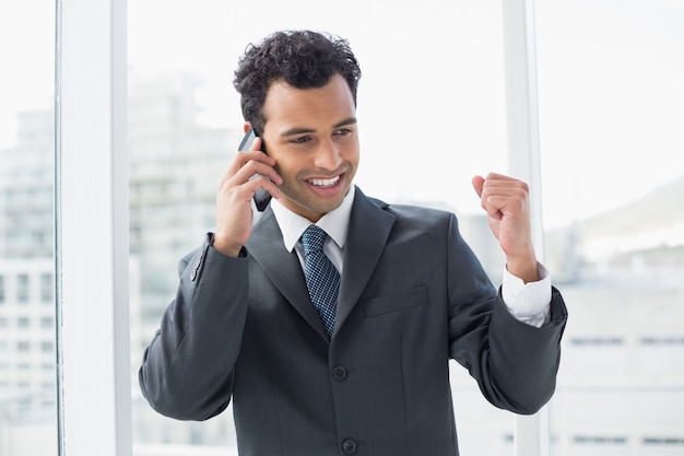 Elegant young businessman using cellphone in office