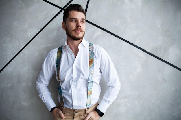 Elegant young handsome man. Good looking young man standing against grey background