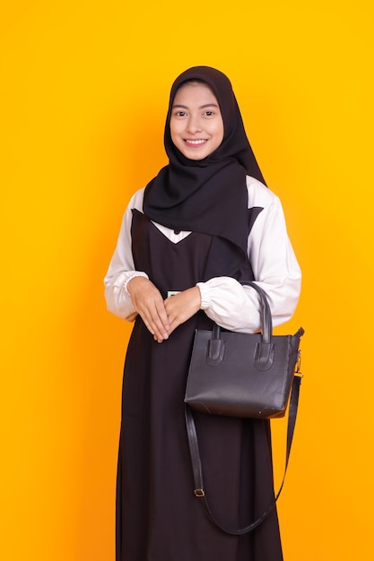 elegant young muslim woman carrying black bag