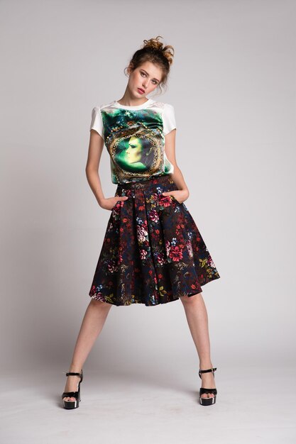 Photo elegant young woman in black floral pattern long skirt, t-shirt posing on white background