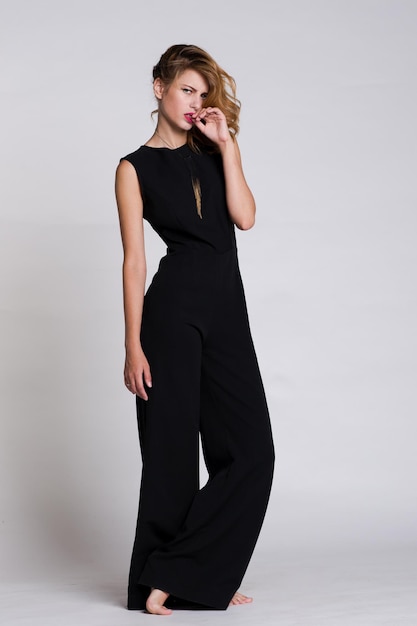 Premium Photo | Elegant young woman in black jumpsuit posing on white ...