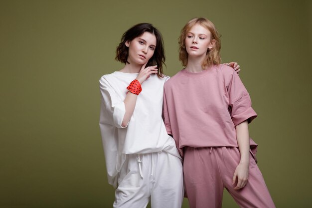 elegant young women in pretty white and pink sports suit, walking style on green background