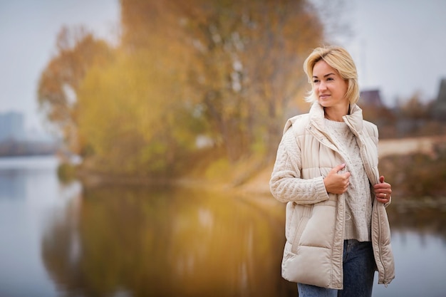 Elegante blondy vrouw wandelen en ontspannen buiten in de herfst