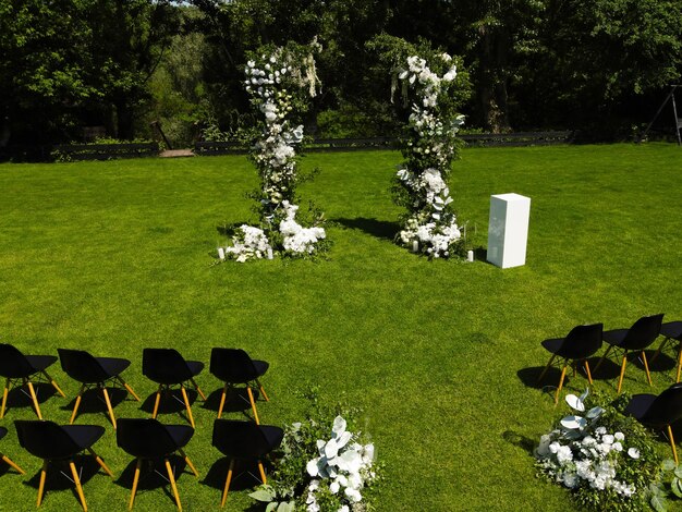 Elegante boog voor de huwelijksceremonie versierd met witte bloemen en groen groen