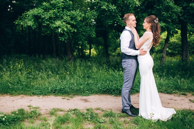 Elegante bruid en bruidegom poseren samen buiten op een trouwdag