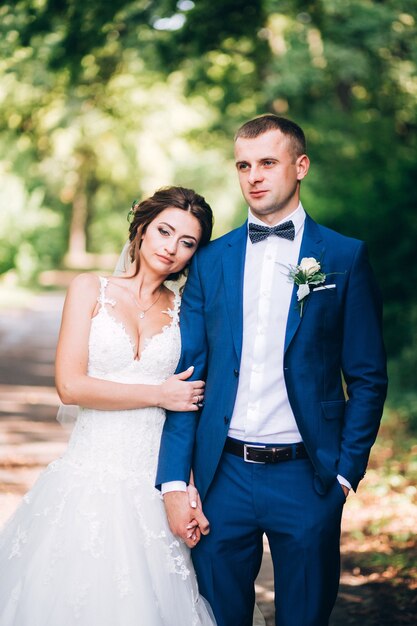 Elegante bruid en bruidegom poseren samen buiten op een trouwdag