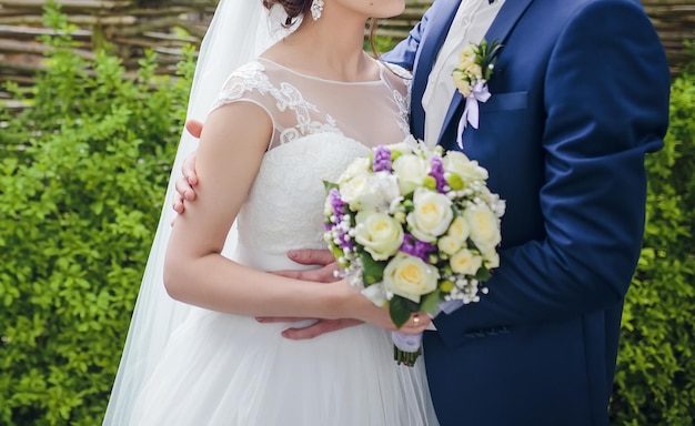 Elegante bruid en bruidegom poseren samen buitenshuis