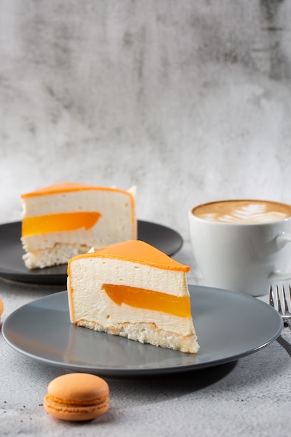 Elegante cake met kokos, passievrucht, mango's en bananen, bedekt met chocoladeglazuur. Segment van oranje gelaagde cake op marmeren achtergrond. Wallpaper voor gebak café of café menu. verticaal.