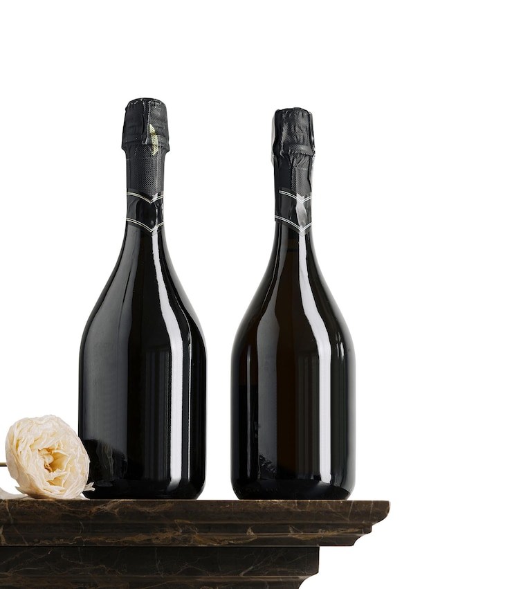 Foto elegante champagneflessen met een delicate bloem op een marmeren plank