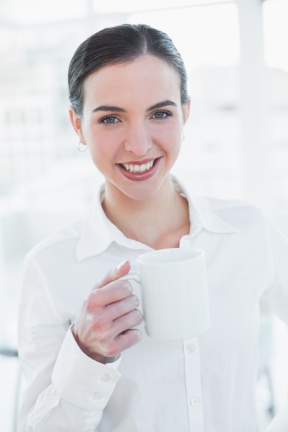 Elegante de koffiekop van de onderneemsterholding in bureau