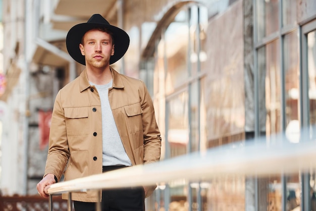 Foto elegante jonge man in zwarte hoed en formele stijlvolle kleding buiten in de stad